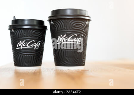 KIEV, UKRAINE / Novembre 06, 2019 : McDonald's Coffee en noir tasses McCafe sur table en bois sur fond clair. Banque D'Images
