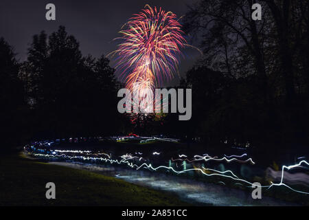 Light trails de gens tenant leurs téléphones et marche vers un feu d'artifice au Pays de Galles, Royaume-Uni Banque D'Images