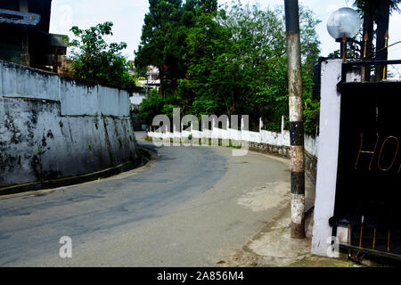 La route le long d'un mur élevé dans les collines de Shillong avec beaucoup d'arbres et de verdure Banque D'Images