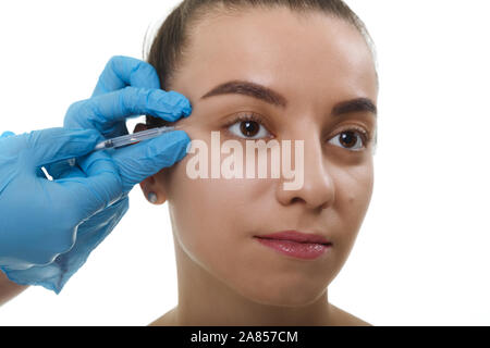 Coiffeur gros plan de la peau du visage Lifting mains faisant de l'injection pour une femme. Belle jeune femme visage et main dans la main avec seringue making injection. Banque D'Images