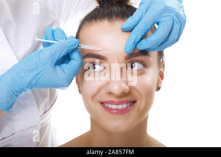 Closeup Portrait of young Caucasian woman getting injection cosmétique dans le front. Les gens, la cosmétologie, la chirurgie plastique et la beauté concept. Banque D'Images