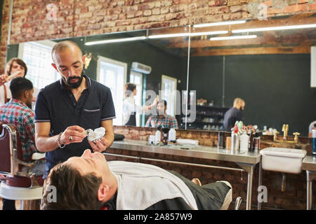 Coiffure homme visage rasage à la préparation du client dans un salon de barbier Banque D'Images
