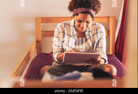 Young female college student using digital tablet on chambre dortoir lits superposés Banque D'Images