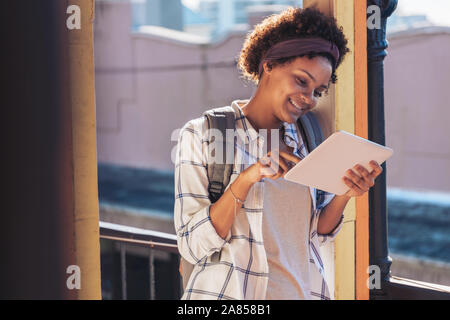Young woman using digital tablet sur balcon ensoleillé Banque D'Images