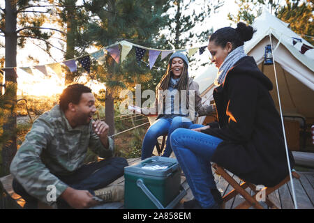 Happy friends jeux de cartes chez camping dans les bois Banque D'Images