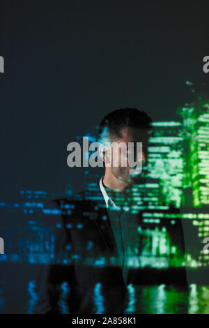Double exposition thoughtful businessman contre cityscape at night Banque D'Images
