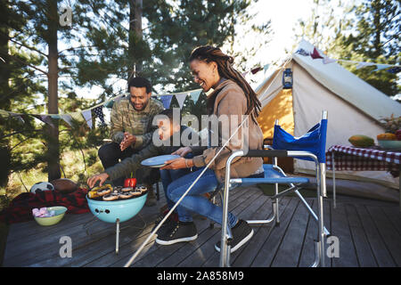 Cuire les légumes de la famille de camping grill Banque D'Images