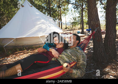 Heureux, insouciant family relaxing in hammock de camping dans les bois Banque D'Images