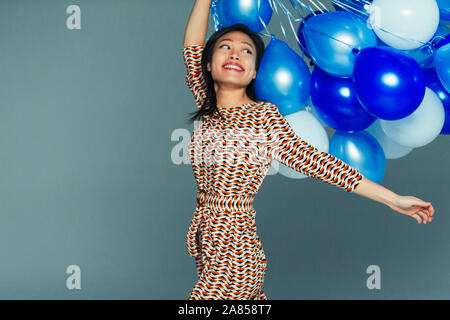 Jeune femme insouciante avec bouquet de ballons bleu Banque D'Images