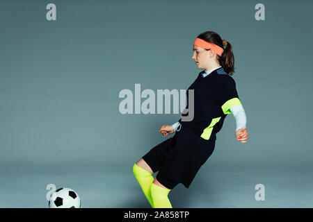 Teenage girl soccer player kicking soccer ball Banque D'Images