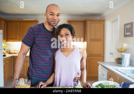 Portrait smiling couple cooking in kitchen Banque D'Images