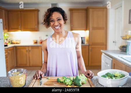 Portrait souriant, confiant woman cooking in kitchen Banque D'Images