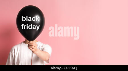 Femme tenant ballon en main cachant son visage sur Rose Banque D'Images