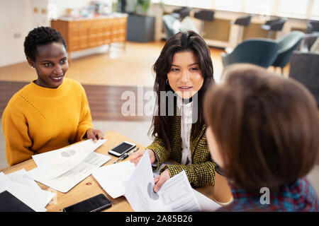 Businesswomen discussing paperwork in meeting Banque D'Images