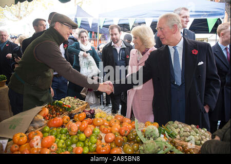 Le Prince de Galles et la duchesse de Cornouailles rencontrez un vendeur de fruits et légumes au cours d'une visite à l'établissement Swiss Cottage Farmers' Market à Londres. Banque D'Images