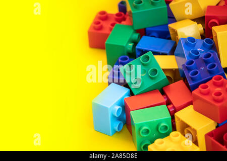 Blocs de construction en plastique coloré briques jouet avec place pour vous les textes et contenu. Banque D'Images
