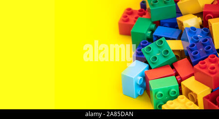 Blocs de construction en plastique coloré briques jouet avec place pour vous les textes et contenu. Banque D'Images