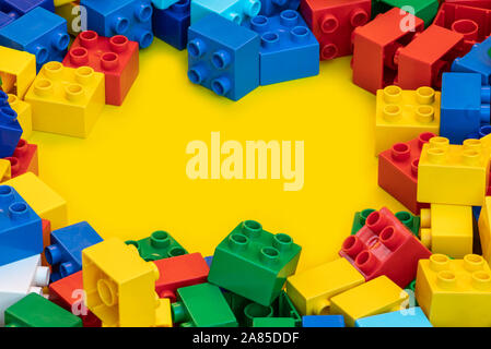 Blocs de construction en plastique coloré briques jouet avec place pour vous les textes et contenu. Banque D'Images