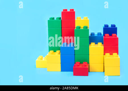 Blocs de construction en plastique Bar graphes toy briques sur fond bleu. Banque D'Images