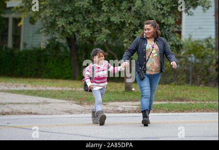 Yanira Lopez marche sa fille Mélany maison de l'école à San Antonio, Texas.. Lopez et ses trois enfants ont fui le Guatemala d'asile aux États-Unis. Banque D'Images