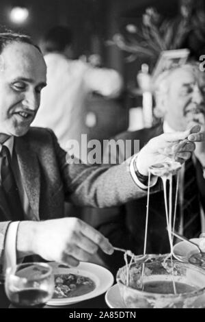 Zwei Männer im Kampf mit einem Schmelzkäse Restaurant à Berlin, Deutschland 1970. Deux hommes qui combattaient avec fromage transformé dans un restaurant à Berlin, Allemagne, 1970. Banque D'Images