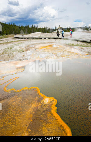 Trois personnes marchant dans la région de geyser Basin, Parc National de Yellowstone Banque D'Images