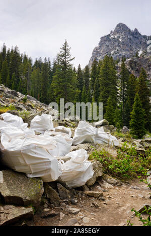 Rochers dans des sacs sur le côté d'un sentier de randonnée de montagne Banque D'Images