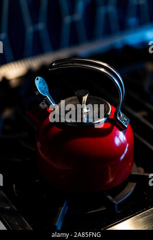 Thé rouge électrique sur le noir de la cuisinière à l'intérieur de la maison Banque D'Images