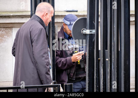 Le journaliste canadien Chris Brown, correspondant étranger de CBC News, a vérifié l'identité par le policier afin d'entrer dans la zone protégée de Downing Street Banque D'Images