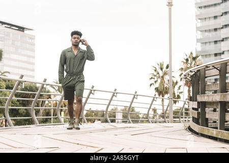 Jeune homme noir africain cool appelant par téléphone pendant la marche dans un parc en plein air dans la ville, le mode de vie et la technologie concept, copie espace pour le texte Banque D'Images