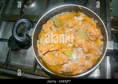 La viande avec les oignons et les carottes à l'étuvée dans une casserole. La cuisine maison Banque D'Images