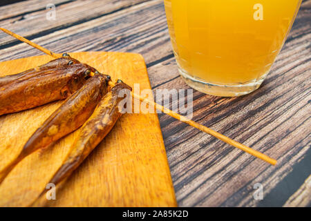 Le Mulet séchés sur une planche en bois avec une chope de bière sur la table. Cuisine poissons et fruits de mer. Snack délicieux Banque D'Images