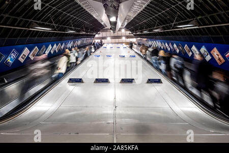 Le métro de Londres. Une longue exposition flou de train de tube les voyageurs et les navetteurs en utilisant les escaliers mécaniques à l'animation de la station de métro London Bridge. Banque D'Images