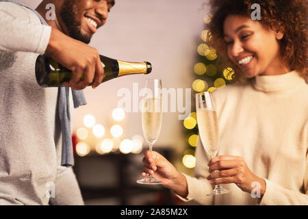 Mari pouring champagne, célébrer Noël avec ma femme Banque D'Images