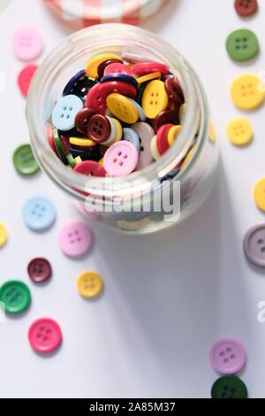 Grand groupe de boutons à coudre en plastique coloré dans une boîte sur la table, avec copie Espace pour le texte Banque D'Images