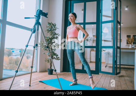 Fitness Trainer portant des poids aux chevilles et filmer tutoriel Banque D'Images