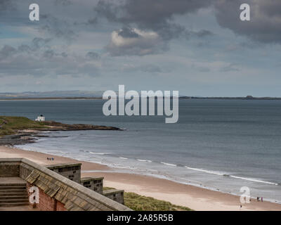 Voir l'île de Lindisfarne (saints) à travers la plage et la mer du château de Bamburgh, Northumberland, Angleterre. Banque D'Images