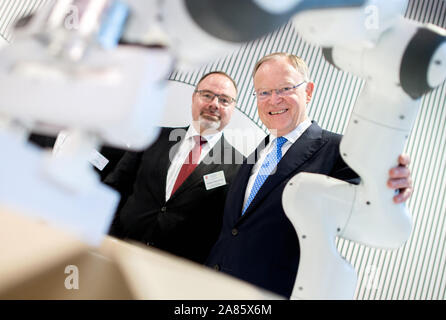 06 novembre 2019, Hanovre, Basse-Saxe : Stephan Weil (r, SPD), Ministre-président de Basse-Saxe, et Dietmar Harhoff, professeur à l'Institut Max Planck pour l'innovation et la concurrence, examinons le robot 'Panda' de la Fondation Robokind dans le futur espace de réunion avant un spécialiste de la Basse-saxe Commission 2030 commence. Le comité scientifique lancé par le Ministre Président Weil est en train de discuter avec des experts quelles mesures doivent être prises pour assurer que l'Arizona continue à avoir du succès dans le monde numérique à l'avenir. Photo : afp/Hauke-Christian Dittrich Banque D'Images