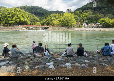 Uji, Japon - les personnes âgées assis à côté de la rivière sur une journée ensoleillée d'automne Banque D'Images