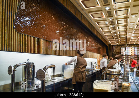 Intérieur de l'Venchi glace, chocolat boutique dans le centre de Florence avec une fontaine de chocolat sur le mur derrière le comptoir, Toscane, Italie Banque D'Images