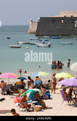 Vue sur l'animation de Playa La Caleta avec le château Castillo de Santa Catalina derrière sous le soleil d'après-midi d'été, Cadix, Andalousie, Espagne, Europe Banque D'Images