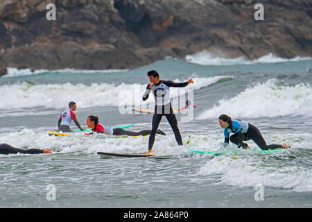 Adolescent, les surfeurs, les garçons et les filles à apprendre à monter sur des planches de vagues Banque D'Images