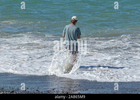 Homme debout en surf avec route pêche Banque D'Images