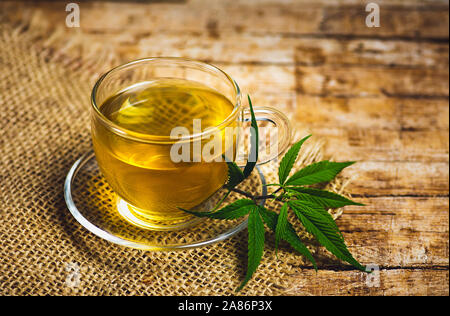 Tisane de marijuana dans un verre et feuilles de cannabis Banque D'Images