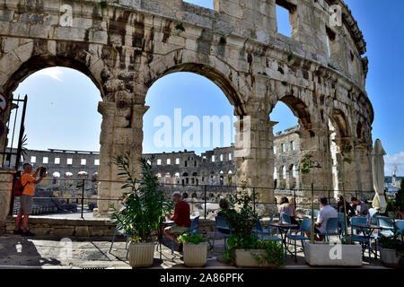 Cafe juste à l'extérieur de l'amphithéâtre romain de Pula anciennes dans le centre-ville peut encore se pencher sur arena, Croatie Banque D'Images