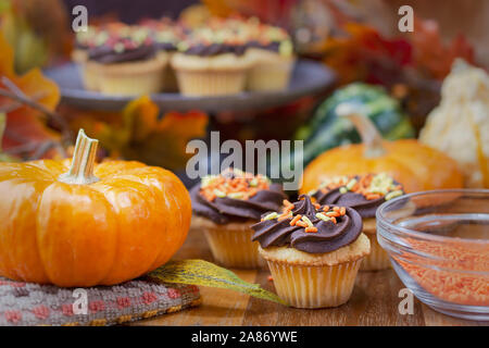 Le thème de l'automne mini cupcakes. Yellow cake au chocolat avec glaçage orange, rouge, jaune et paillettes. Banque D'Images