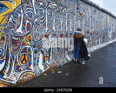 BERLIN, ALLEMAGNE, Octobre 6, 2017 : les touristes posant à côté du mur de Berlin en Allemagne Banque D'Images