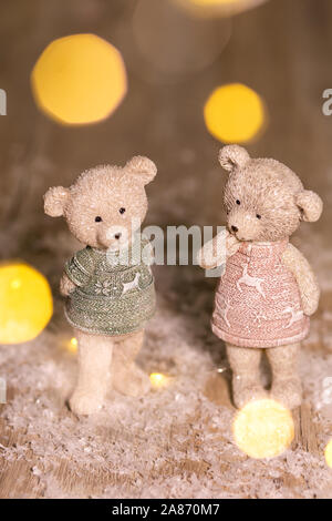 Figurines décoratives d'un thème de Noël. Univers miniatures d'adorables nounours d'un garçon et une fille dans les chandails avec des daims. Décor de fête, chaud bokeh lights Banque D'Images