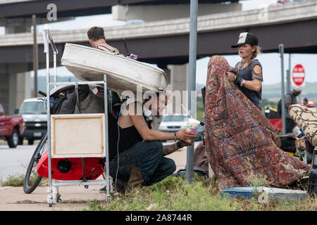 Ray Harvey et récolte compagnon Ray Harvey pile leurs affaires près d'un camp de sans-abri temporaire en vertu d'un viaduc en tant que travailleurs de l'état nettoyer le campement. Texas Gov. Greg Abbott a ordonné le retrait des camps de sans-abri sur les voies de passage publiques dans 17 sites autour de la ville. Banque D'Images