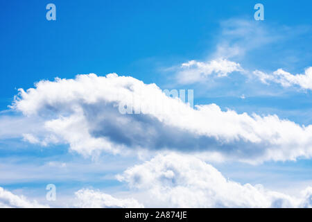 Dramatique nuages duveteux ensoleillée contre un ciel d'été bleu Banque D'Images